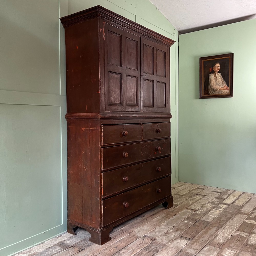 An early 19th-century Irish painted pine press cupboard with two panelled upper doors over a base section containing five drawers. View VIII