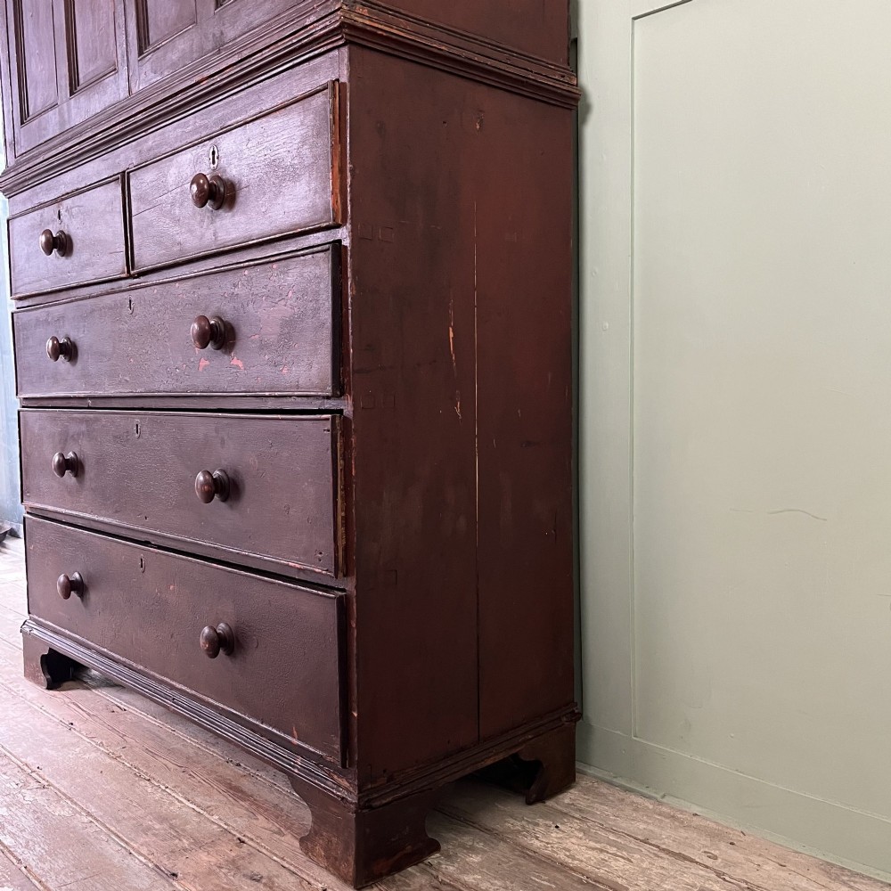 An early 19th-century Irish painted pine press cupboard with two panelled upper doors over a base section containing five drawers. View IX