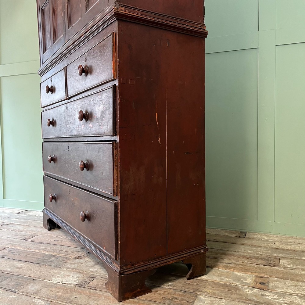 An early 19th-century Irish painted pine press cupboard with two panelled upper doors over a base section containing five drawers. View XIV