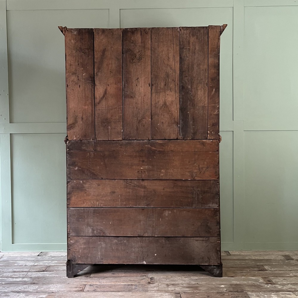 An early 19th-century Irish painted pine press cupboard with two panelled upper doors over a base section containing five drawers. View XV