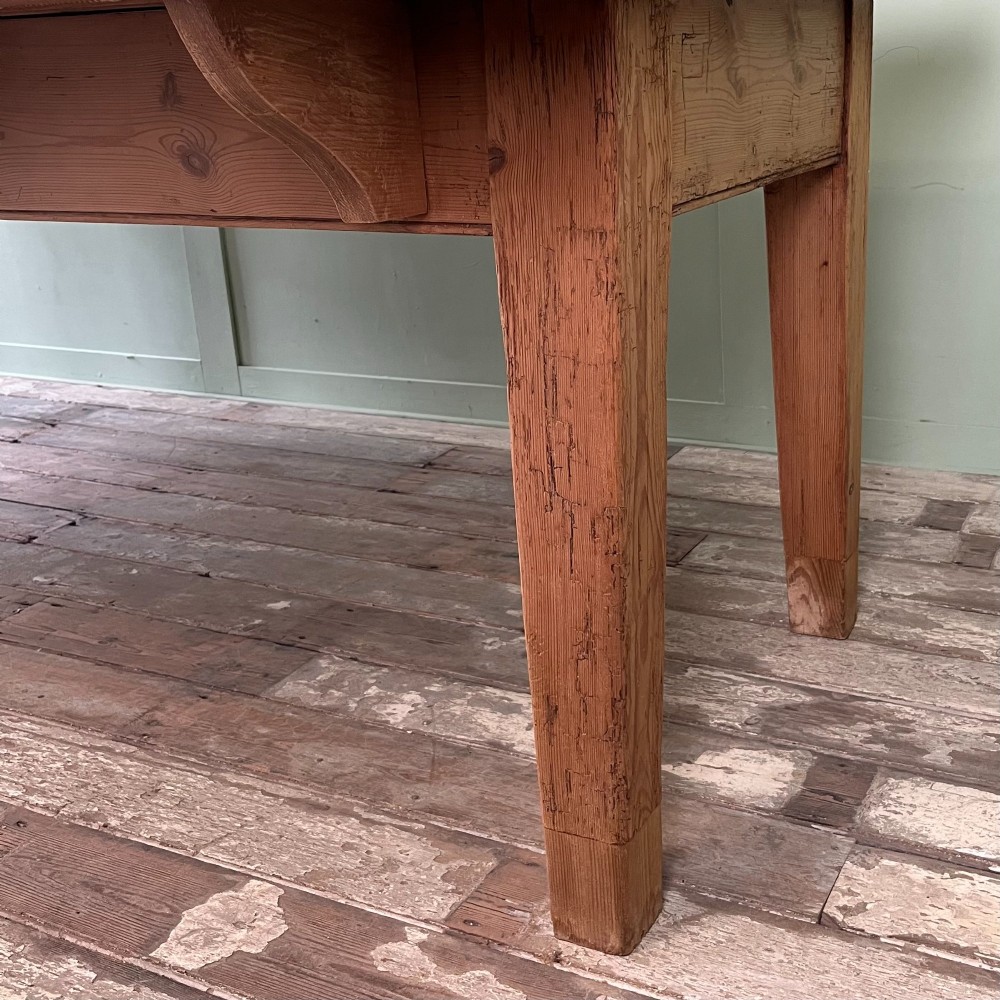A large Victorian pine farmhouse dining table featuring a multi-plank top, deep apron with supporting brackets, and four straight tapered legs. View VII