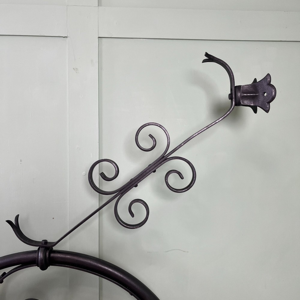 A pair of large metal street lanterns with glazed glass panels alongside two large decorative scrolled wrought iron wall brackets. View VI