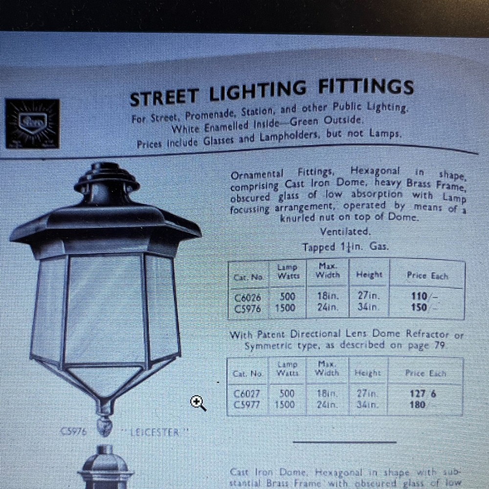 A pair of large metal street lanterns with glazed glass panels alongside two large decorative scrolled wrought iron wall brackets. View XIV