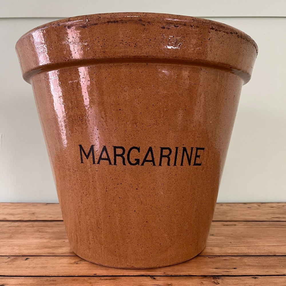 A large tan glazed stoneware bowl with a flared rim and the word MARGARINE stencilled in black lettering across the front. View V