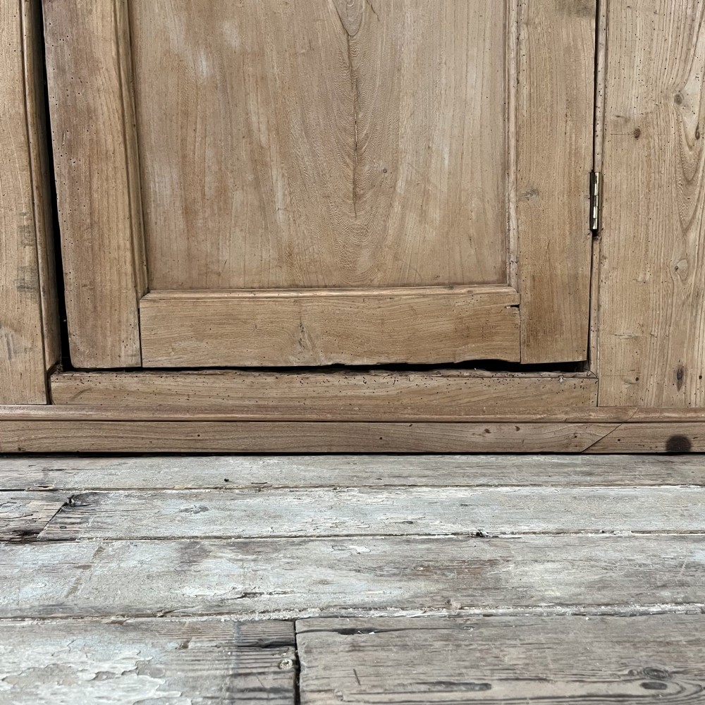 An 18th-century Welsh standing elm food cupboard featuring twin panelled doors open to reveal multiple interior shelves set against a pale background. View VI