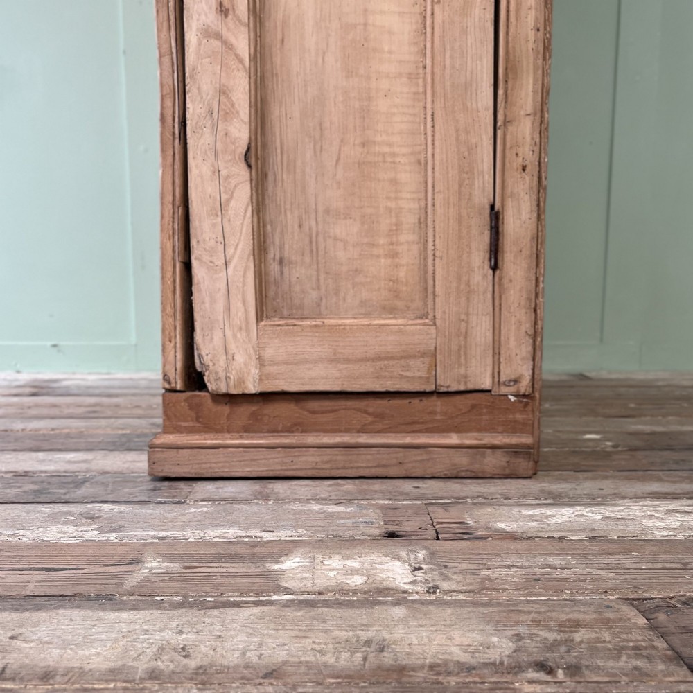 An 18th-century Welsh standing elm food cupboard featuring twin panelled doors open to reveal multiple interior shelves set against a pale background. View XII