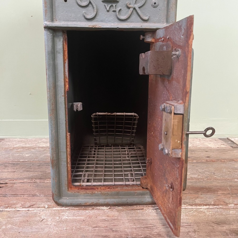 A cast iron George VI post box with a raised GR Royal cypher alongside a tall matching metal pedestal stand. View IX