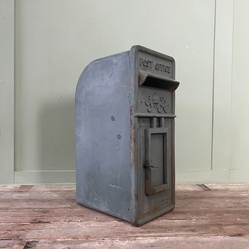 A cast iron George VI post box with a raised GR Royal cypher alongside a tall matching metal pedestal stand. View XIV