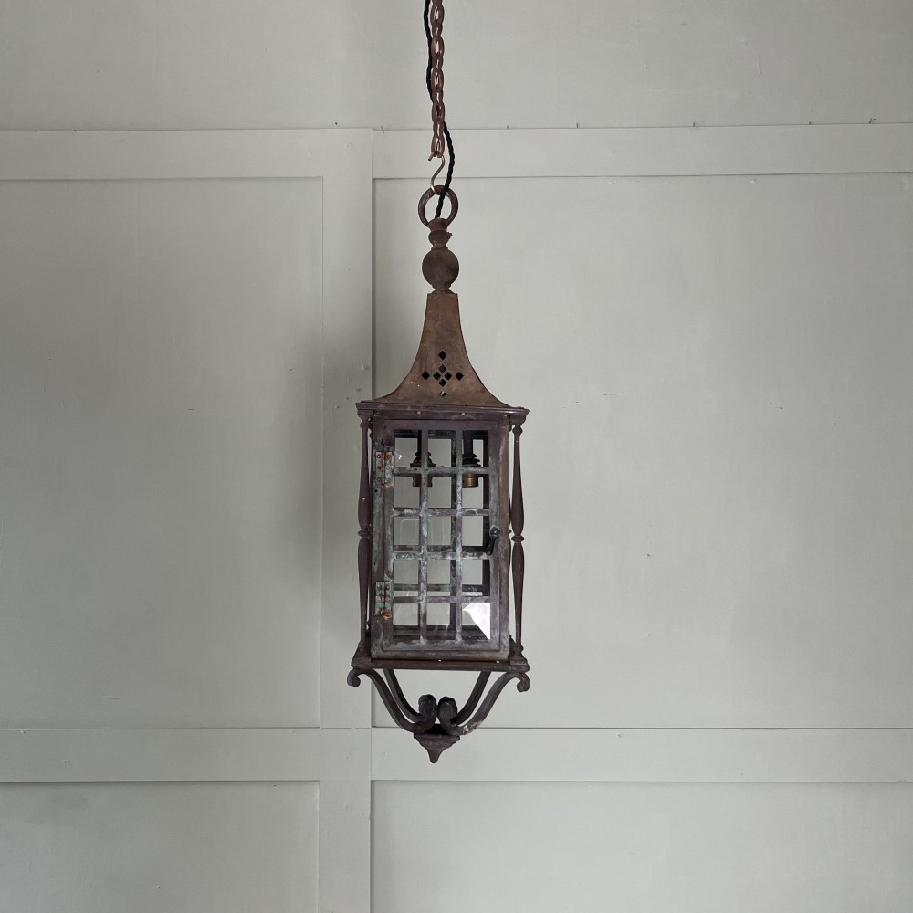 An Edwardian rectangular brass hanging lantern light fixture with glazed window panels, internal bulb fittings, a pagoda top, and a lower scroll finial. View III