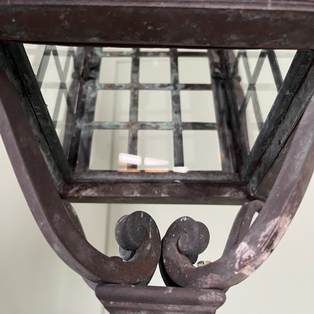 An Edwardian rectangular brass hanging lantern light fixture with glazed window panels, internal bulb fittings, a pagoda top, and a lower scroll finial. View VIII