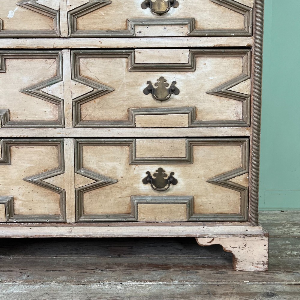 An Edwardian painted chest of drawers featuring eight drawer fronts decorated with geometric panel mouldings, drop handles, and rope-twist edge detailing. View IV