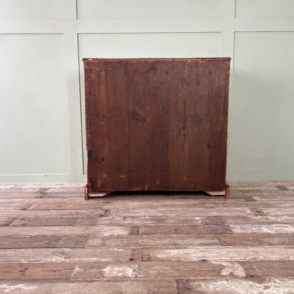 An Edwardian painted chest of drawers featuring eight drawer fronts decorated with geometric panel mouldings, drop handles, and rope-twist edge detailing. View VI