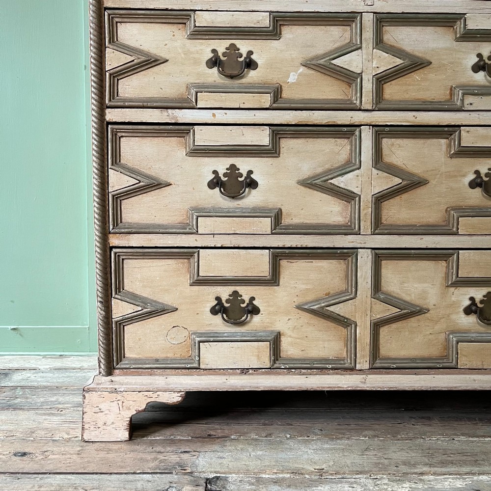 An Edwardian painted chest of drawers featuring eight drawer fronts decorated with geometric panel mouldings, drop handles, and rope-twist edge detailing. View VIII