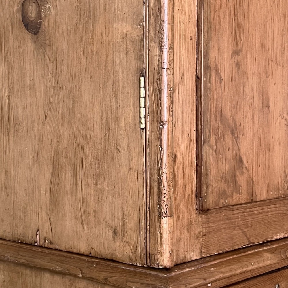 An antique Victorian pine cupboard on chest featuring a top section with two arched panel doors above three drawers with turned wooden handles. View VI