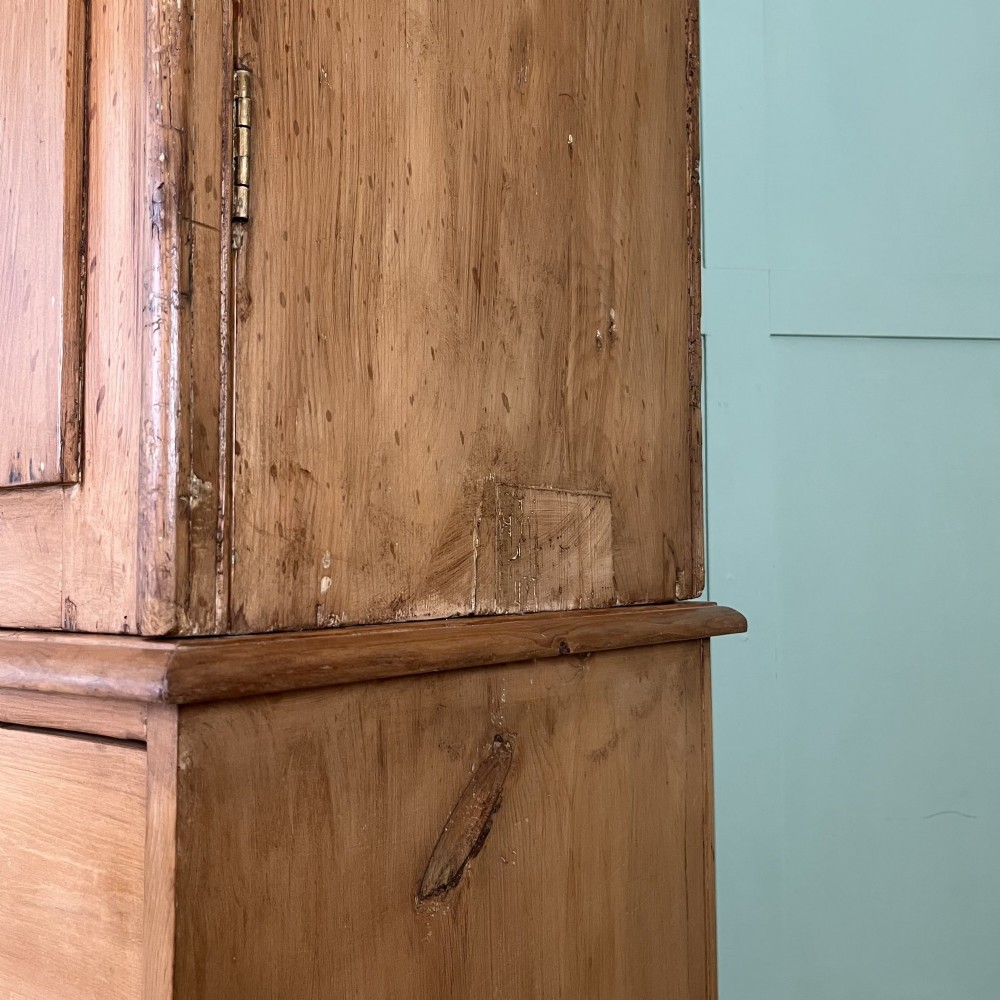 An antique Victorian pine cupboard on chest featuring a top section with two arched panel doors above three drawers with turned wooden handles. View XIV