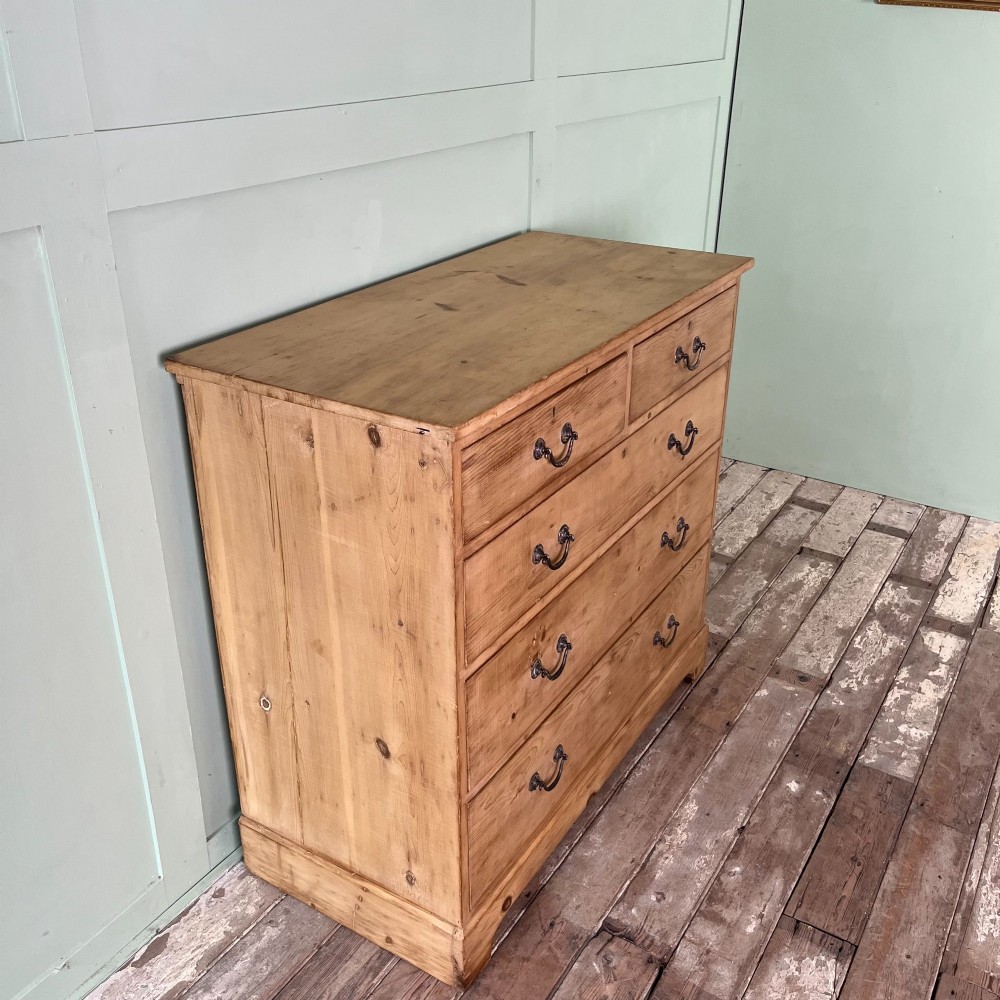 A Victorian natural pine chest of drawers featuring two short drawers over three long drawers with metal drop handles. View II