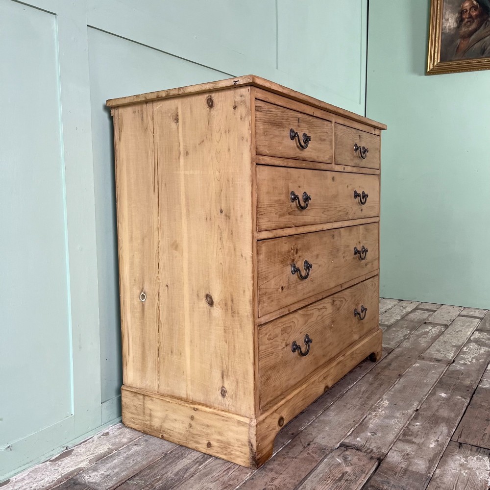 A Victorian natural pine chest of drawers featuring two short drawers over three long drawers with metal drop handles. View III