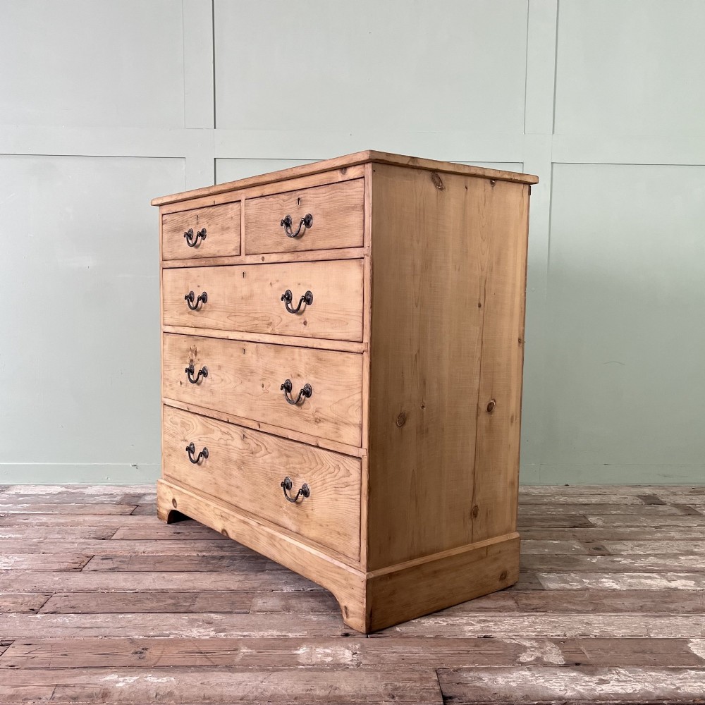 A Victorian natural pine chest of drawers featuring two short drawers over three long drawers with metal drop handles. View IV