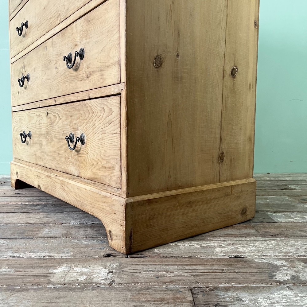 A Victorian natural pine chest of drawers featuring two short drawers over three long drawers with metal drop handles. View V