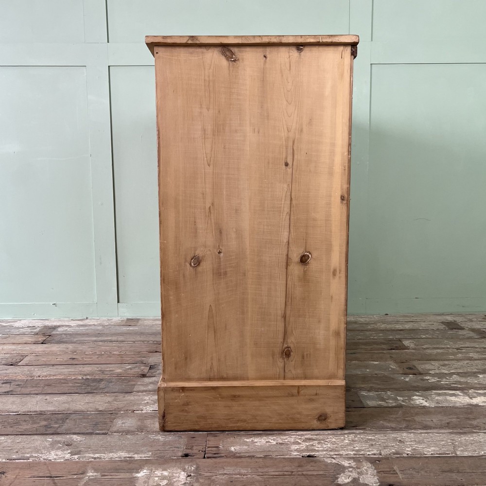A Victorian natural pine chest of drawers featuring two short drawers over three long drawers with metal drop handles. View VI