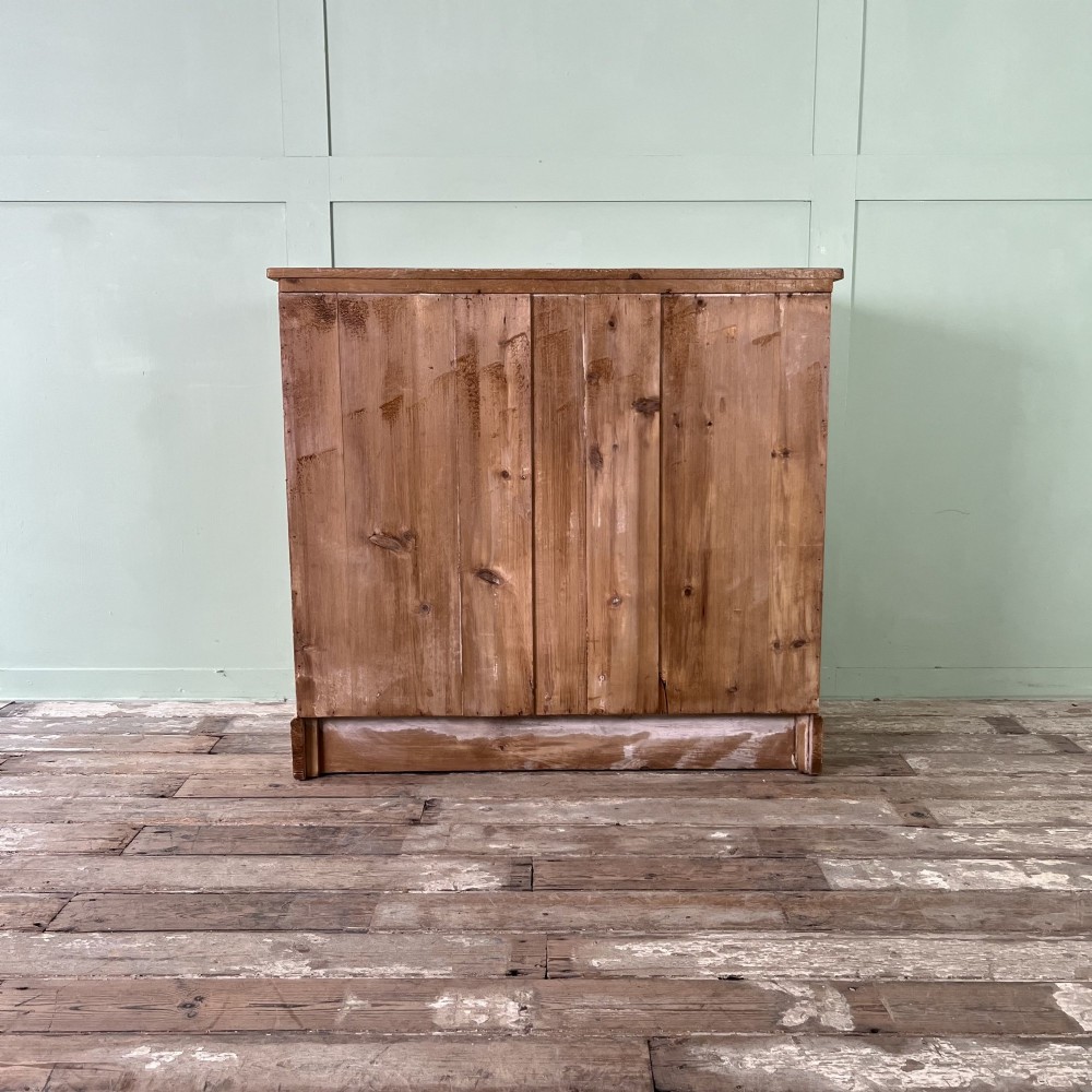 A Victorian natural pine chest of drawers featuring two short drawers over three long drawers with metal drop handles. View VII