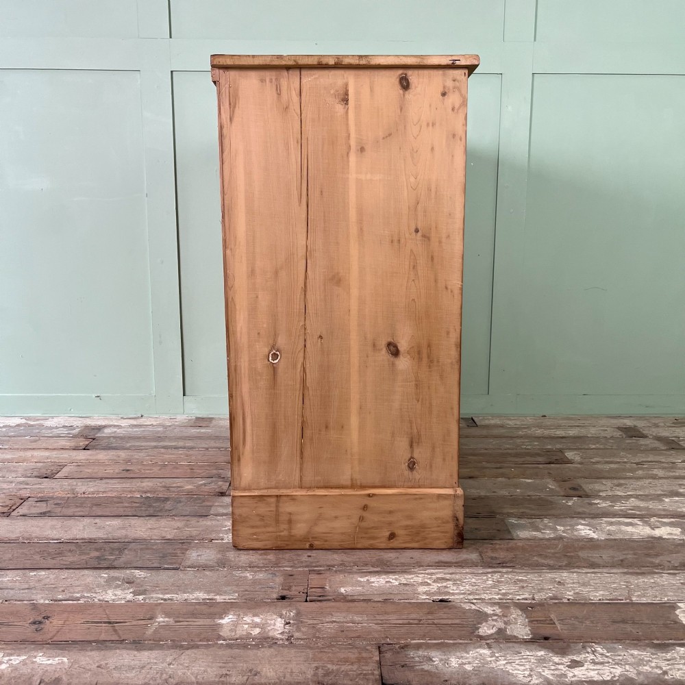 A Victorian natural pine chest of drawers featuring two short drawers over three long drawers with metal drop handles. View VIII