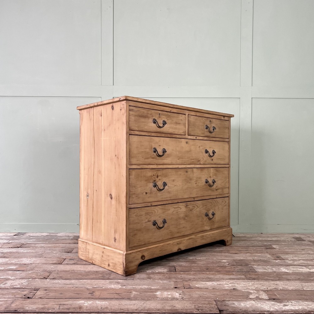 A Victorian natural pine chest of drawers featuring two short drawers over three long drawers with metal drop handles. View IX