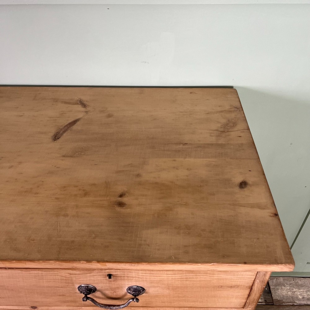 A Victorian natural pine chest of drawers featuring two short drawers over three long drawers with metal drop handles. View X