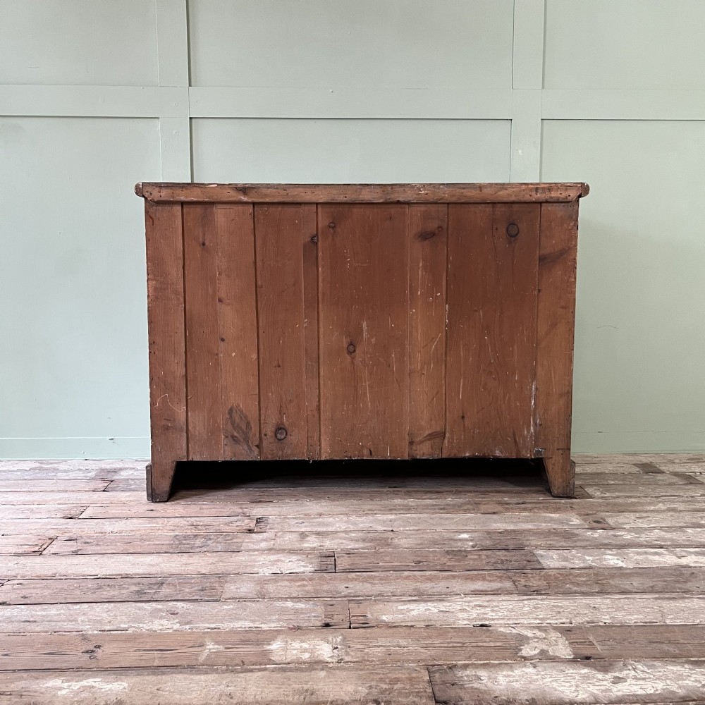 An antique Victorian warm brown pine cupboard featuring three drawers on the left with turned wooden knobs alongside a single panelled door on the right. View X