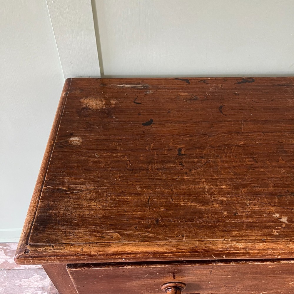 An antique Victorian warm brown pine cupboard featuring three drawers on the left with turned wooden knobs alongside a single panelled door on the right. View XIII