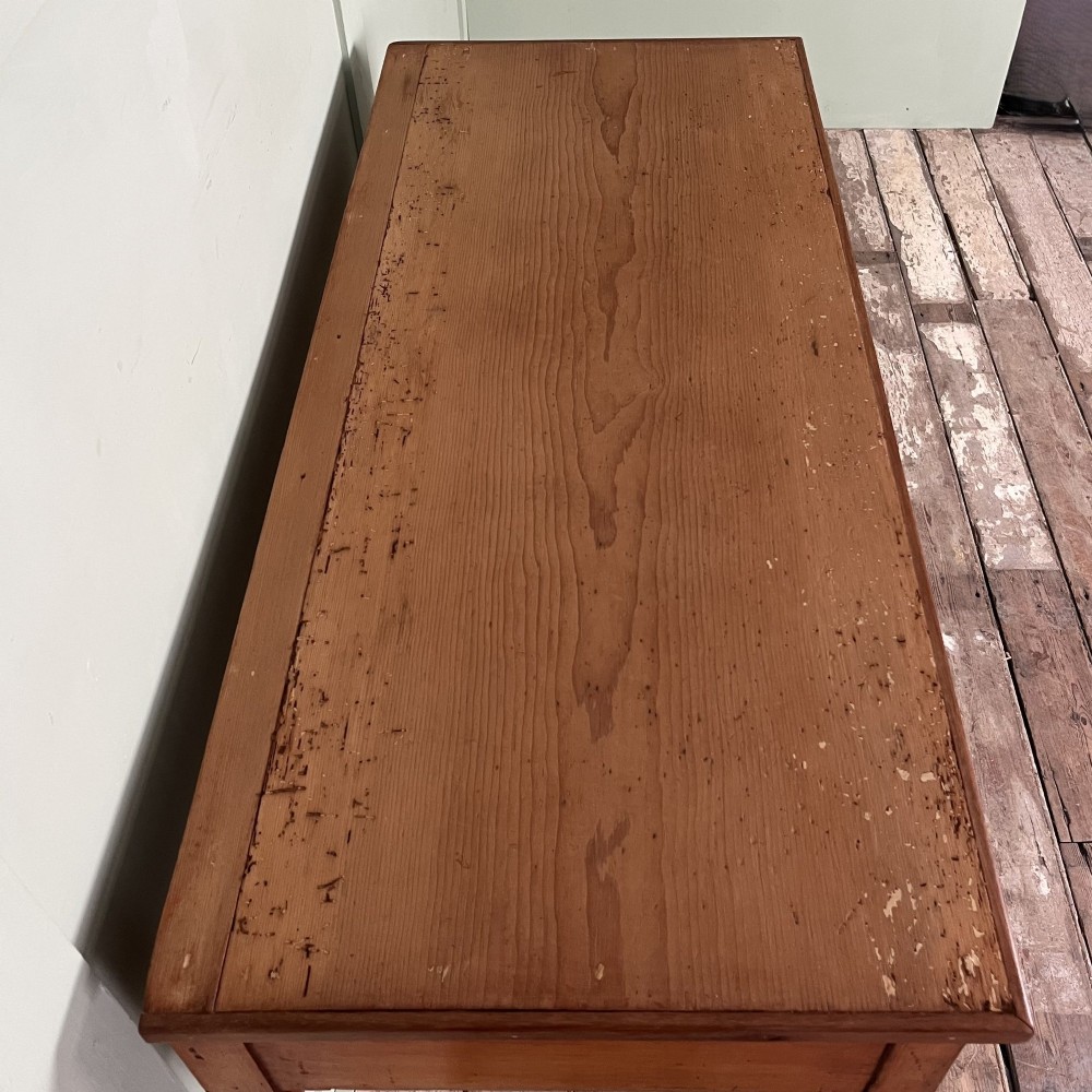 An antique pine hall table featuring two drawers with dark turned handles and slender turned legs. View IX