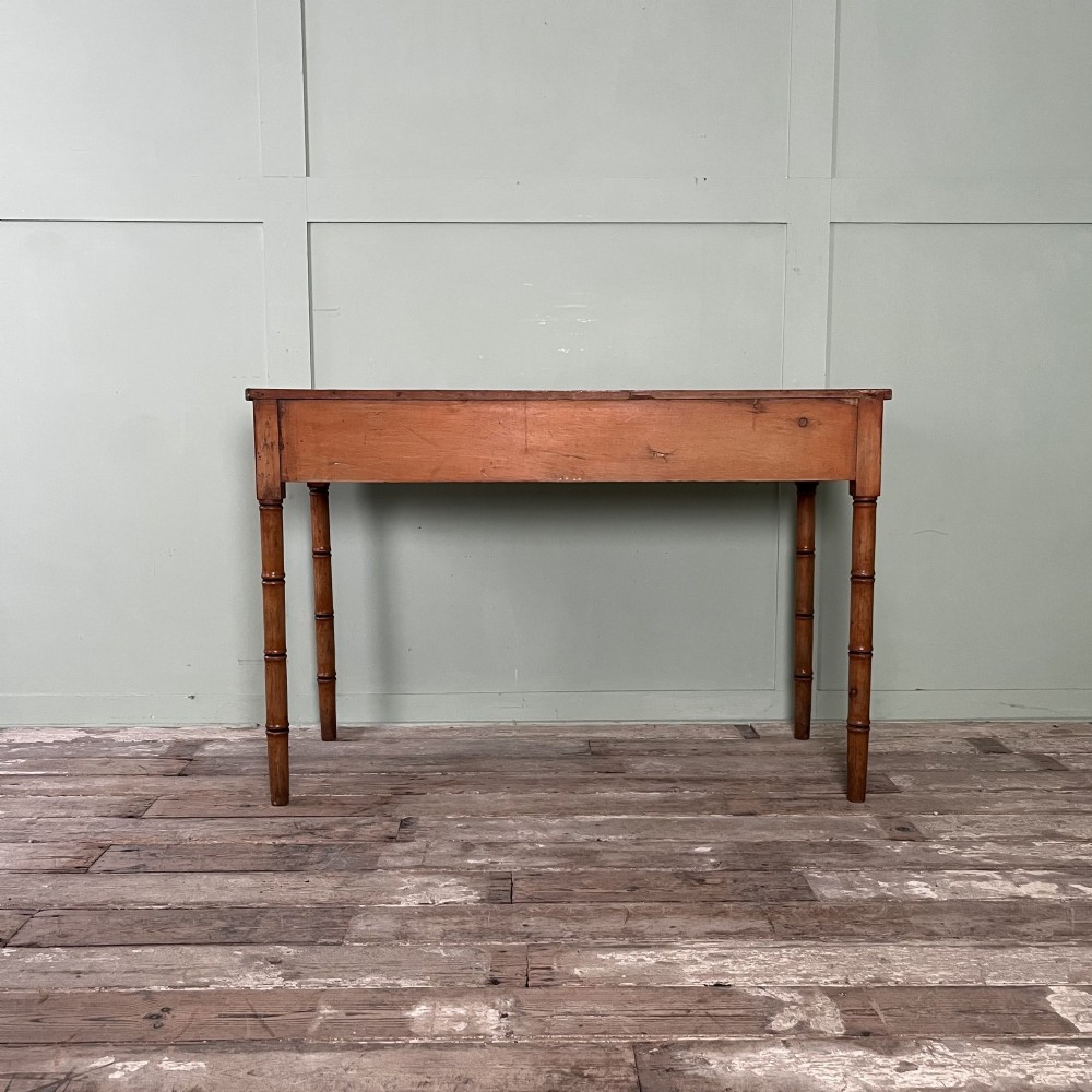 An antique pine hall table featuring two drawers with dark turned handles and slender turned legs. View XI