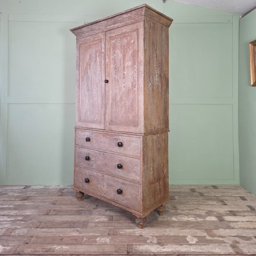 A tall late Georgian painted pine housekeepers cupboard featuring panelled upper doors and three lower drawers on turned feet. View III