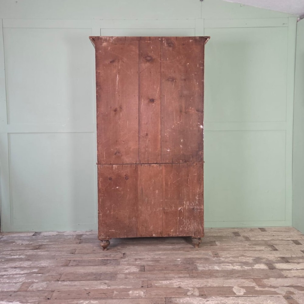 A tall late Georgian painted pine housekeepers cupboard featuring panelled upper doors and three lower drawers on turned feet. View VII