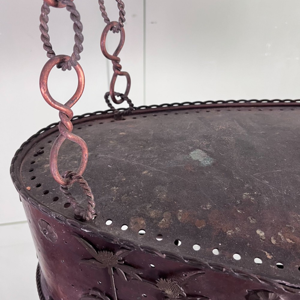 An oval Arts and Crafts copper pendant light featuring hand-chased floral motifs suspended from twin copper link chains with ceiling roses. View XIII
