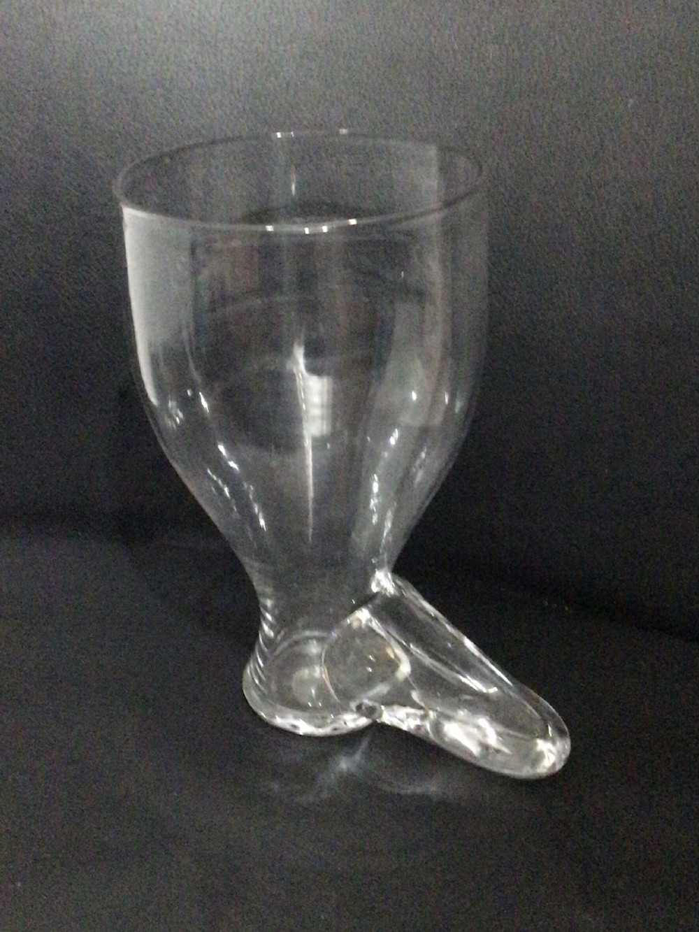 A Georgian clear hand-blown glass drinking vessel crafted in the shape of a boot with a wide rim.