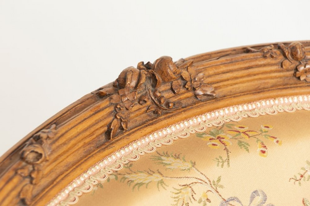 A three-piece antique French salon suite comprising a small canape sofa and two matching armchairs with carved pale walnut frames and gold floral upholstery. View V