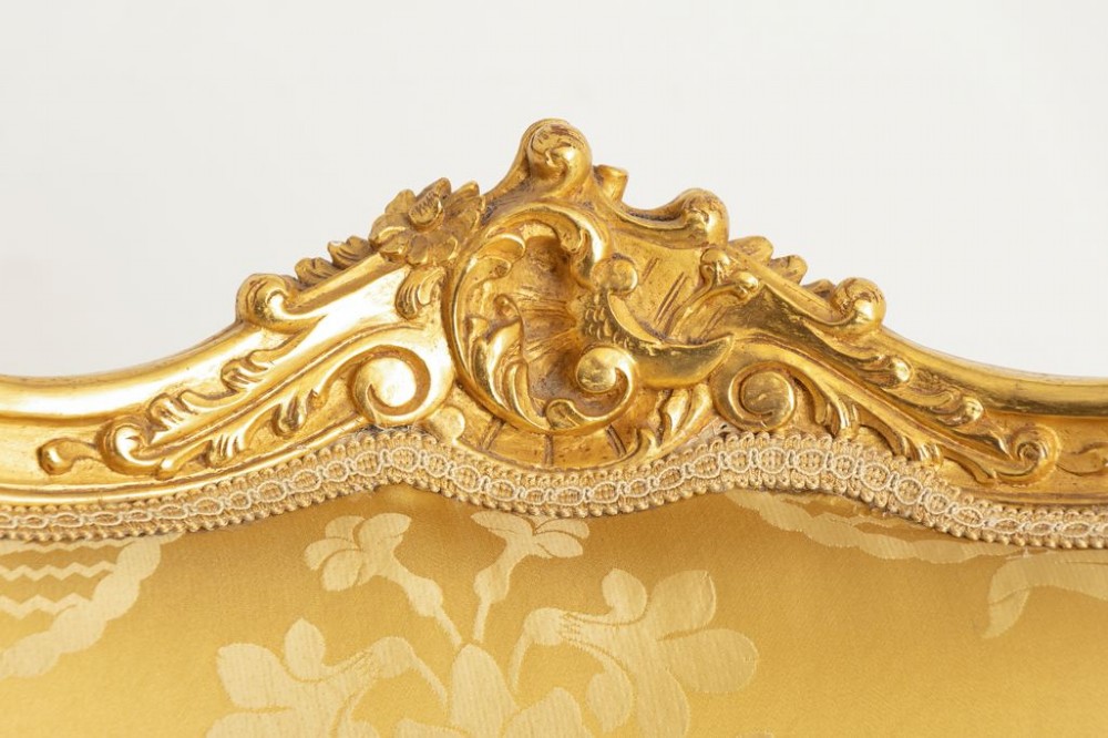 A pair of carved French Rococo giltwood armchairs upholstered in yellow silk floral damask fabric. View III