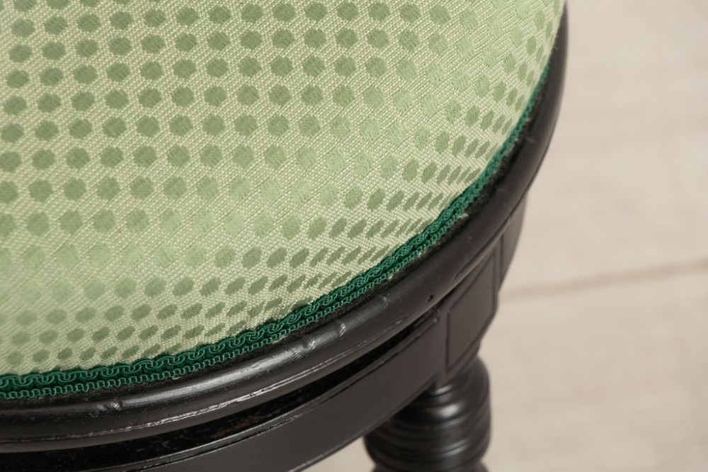 An ebonised wooden swivel piano stool featuring a spindled backrest, turned legs, and a round green upholstered seat. View III