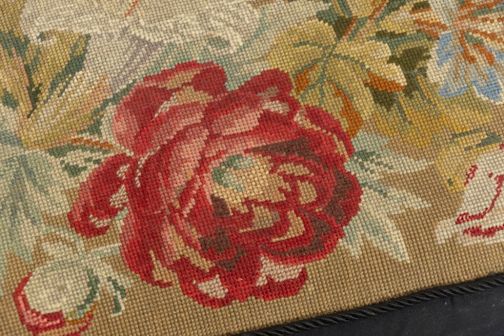 A low rectangular Victorian footstool crafted from carved dark walnut with short cabriole legs and floral tapestry upholstery. View III