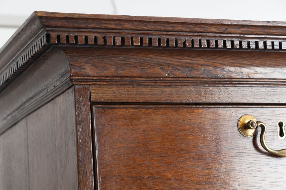 A tall Georgian oak chest on chest featuring two short drawers over five graduated long drawers with brass swan-neck handles and bracket feet. View III