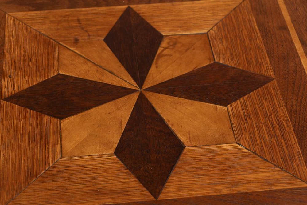 An Arts and Crafts square wooden side table featuring geometric inlaid timber patterns on the top, chamfered legs, a slatted middle shelf, and a solid lower shelf. View III