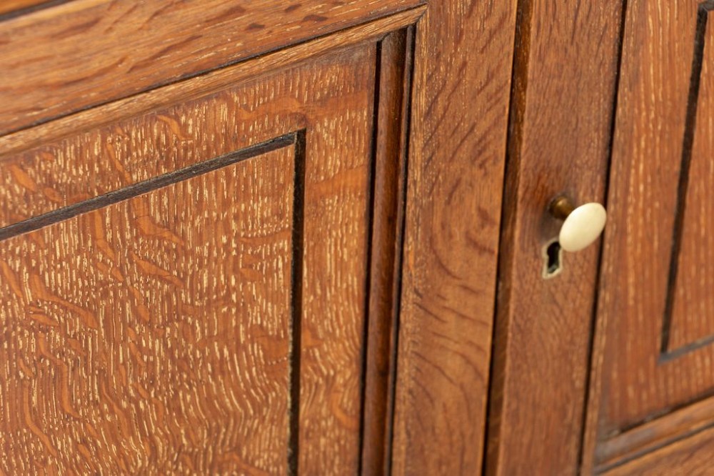 A late 19th-century oak open bookcase featuring two upper shelves above a double-door panelled cupboard base on turned bun feet. View III