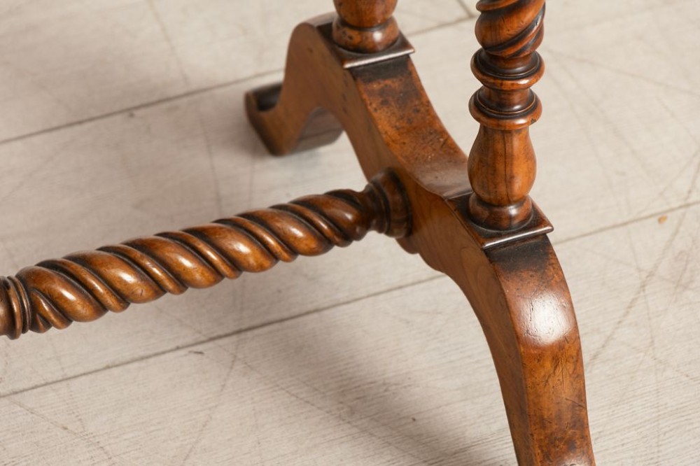 An antique burr walnut sewing table with two drawers, four turned barley twist legs, keyhole details, and a central stretcher base. View IV