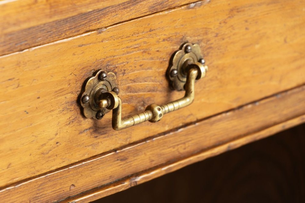 An Edwardian pine pedestal desk featuring nine drawers with brass drop handles and solid plinth bases. View III