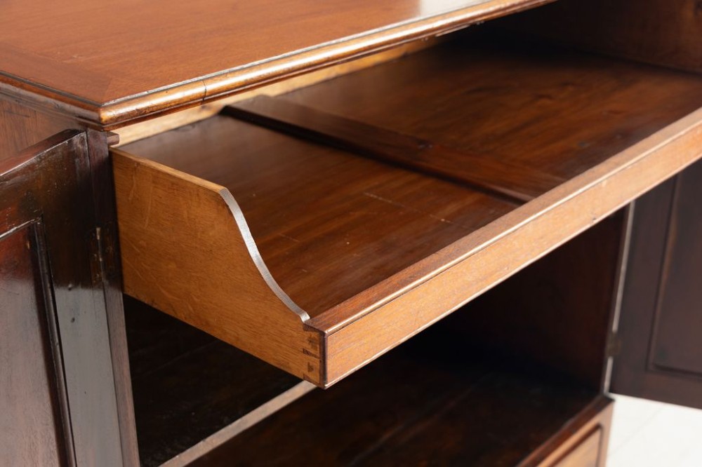 A small Georgian mahogany linen press featuring twin panelled doors with flame grain veneers above a single drawer on a shaped apron base. View IV