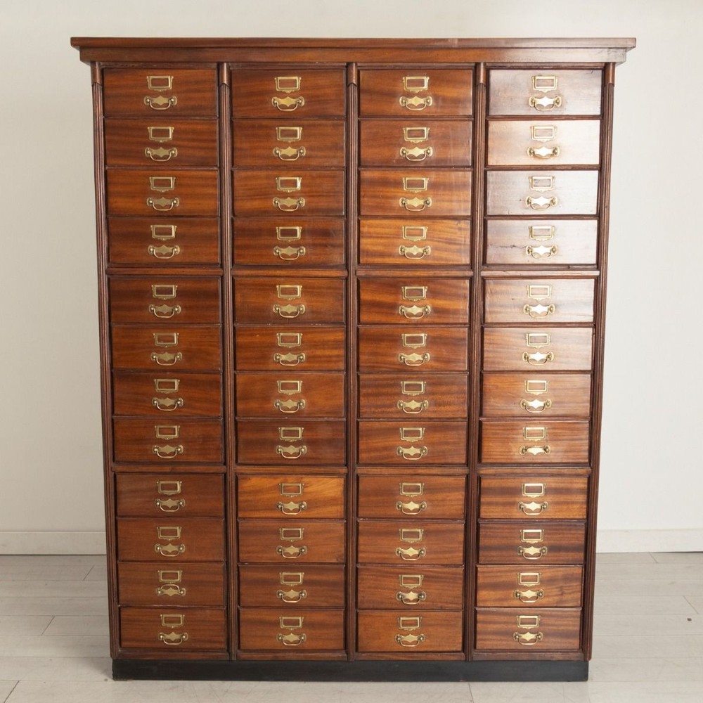 A tall French antique walnut bank of drawers featuring forty-eight small drawers with brass handles and integrated label holders. View II