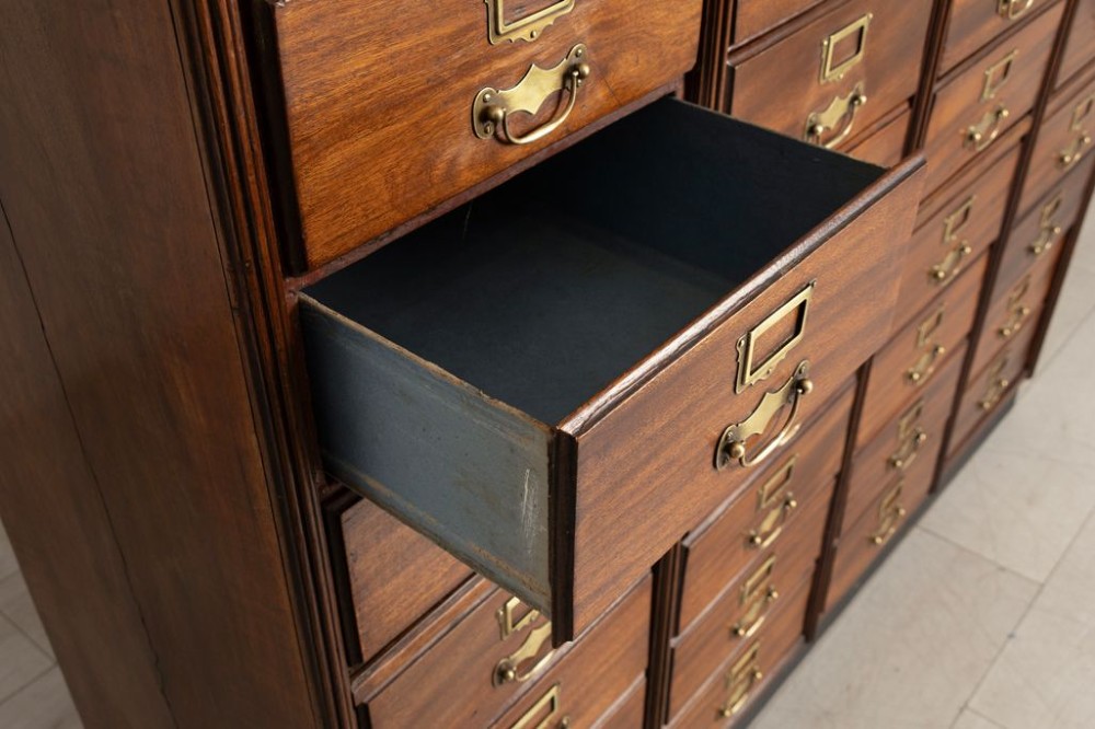 A tall French antique walnut bank of drawers featuring forty-eight small drawers with brass handles and integrated label holders. View III