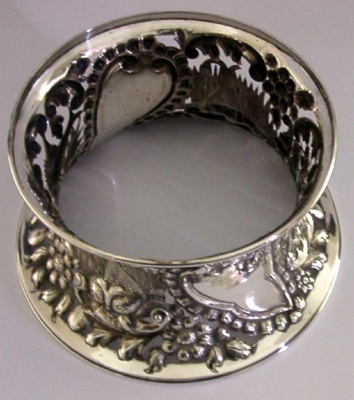 An hourglass-shaped sterling silver dish ring featuring intricately pierced fretwork with floral motifs, scrolls, and marine life details. View VIII