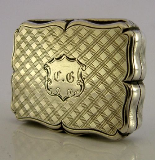 An open Victorian sterling silver vinaigrette box by Nathaniel Mills featuring a scalloped edge, cross-hatch engraving, and an internal hinged pierced gilt grill. View IV